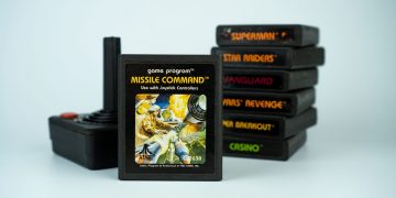 Missile Command video game cartridge standing next to a classic Atari controller and a stack of other games.