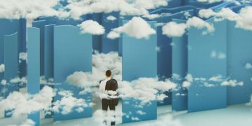 A businessman stands in front of maze strewn with clouds.