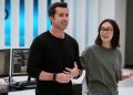 Rob McElhenney and Charlotte Nicdao standing in front of a desk in Mythic Quest Season 3.