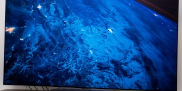 A photo of the LG C2 OLED TV displaying a screensaver of the Earth.