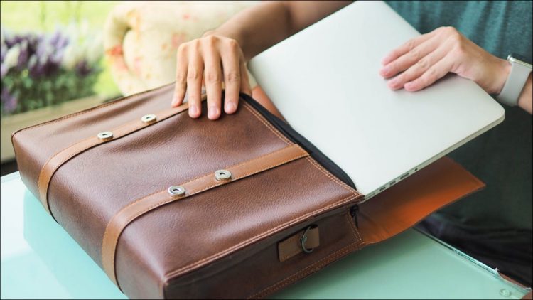 Person packing laptop into laptop bag