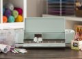 Cricut Explore Air 2 on a desk surrounded by craft supplies.