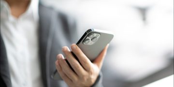 A businessperson holding an iPhone.